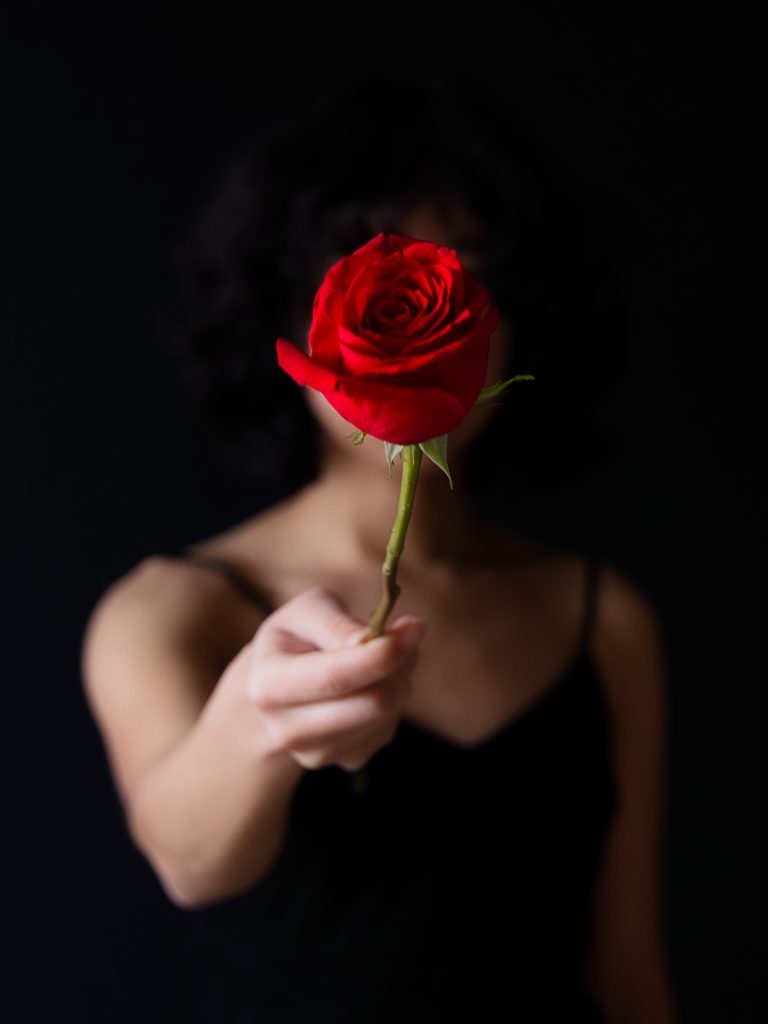 Mujer ofreciendo una rosa